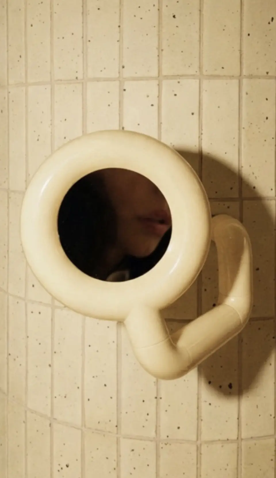 PLSTK Makeup Mirror by Brendan Tadler on speckled tile, with its reflection