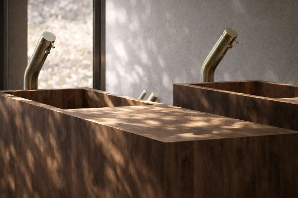 Vanity detail. Modern Master Ensuite, private residence in Amagansett, NY: two wood-clad rectangular vessel sinks with brushed brass faucets in dappled light